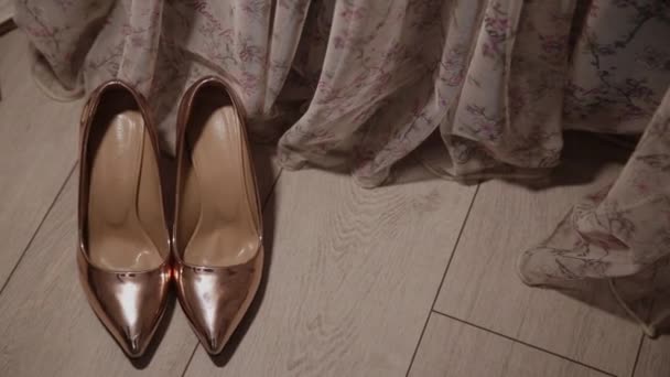 Chaussures femmes dorées sur le sol par le rideau . — Video