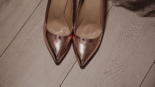 Χρυσό γυναικεία παπούτσια στο πάτωμα από την κουρτίνα. — Αρχείο Βίντεο
