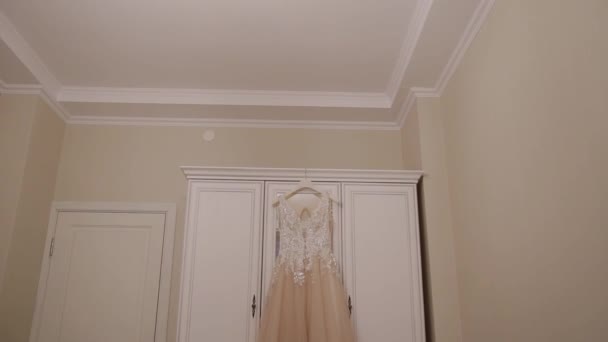 Свадебное платье висит на шкафу в комнате . — стоковое видео