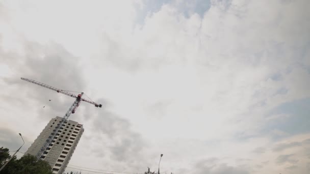 Time-lapse konstruktion tornkran fungerar mot den molniga himlen. — Stockvideo