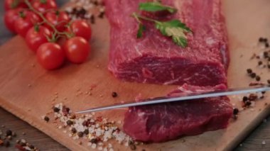 Adam ahşap tahta üzerinde ham sığır eti keser