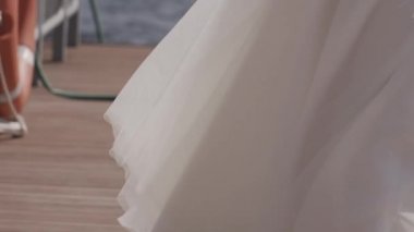 Büyüleyici bir gelin Tilt hassas düğün buket tutarak. Göle yakın duran ve bulutlu bir günde mesafe seyir.