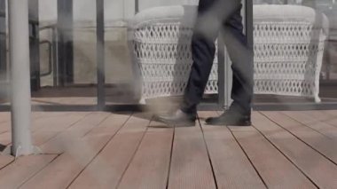 işadamı, yavaş yavaş iskelede yürür.