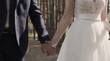 Evlen benimle bugün ve her gün. Yeni evli çift tutuşup, ağır çekimde atış.