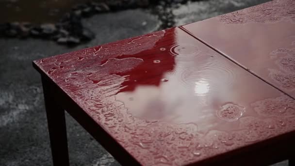 Pluie qui goutte sur une vieille table rouge . — Video