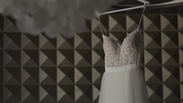 Belo vestido de noiva pendurado em um grande lustre . — Vídeo de Stock