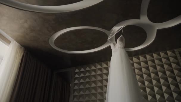 Beautiful wedding dress hanging in a large chandelier. — Stock Video