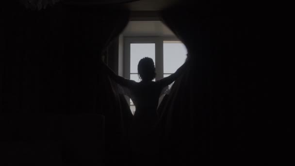 Joven mujer de negocios desvela cortina y mirando por la ventana . — Vídeos de Stock