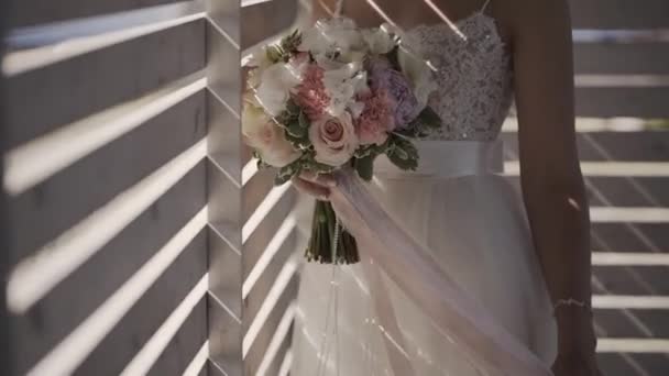 Mariée en robe de dentelle tenant beau bouquet de fleurs de mariage blanc . — Video