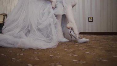 Eller sığ derinlik-in tarla kapatın ayakkabı kadın koyar. Gelin üzerinde lüks yüksek topuklu sandalet düğün töreninde dans için hazırlanmış muhteşem beyaz cüppe Başlarken hazır oturan fermuar takılır.