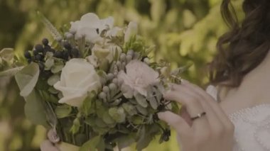 Kadın bir düğün buket güneşli bir günde dokunur.