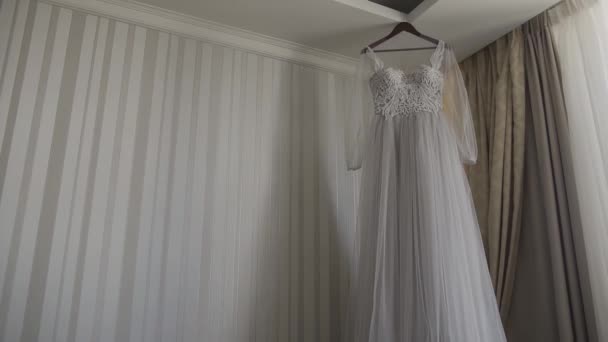 Belle robe de mariée suspendue dans un grand lustre . — Video