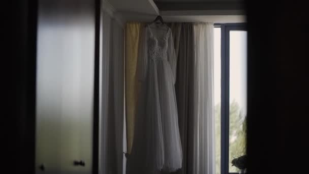 Beautiful wedding dress hanging in a large chandelier. — Stock Video