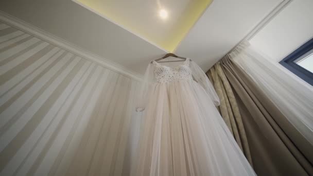 Belle robe de mariée suspendue dans un grand lustre . — Video