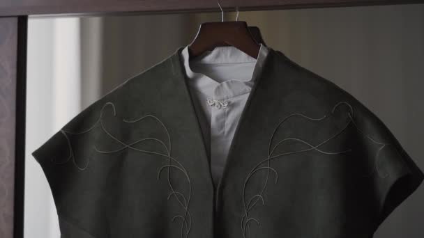 A mans jas hangt op een hanger in de kamer. — Stockvideo