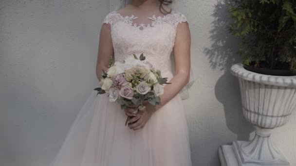 Mariée en robe de dentelle tenant beau bouquet de fleurs de mariage blanc . — Video