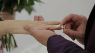 Çok güzel yeni evliler birbirlerine yüzük koymak.