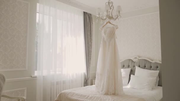 Bellissimo abito da sposa appeso in un grande lampadario . — Video Stock