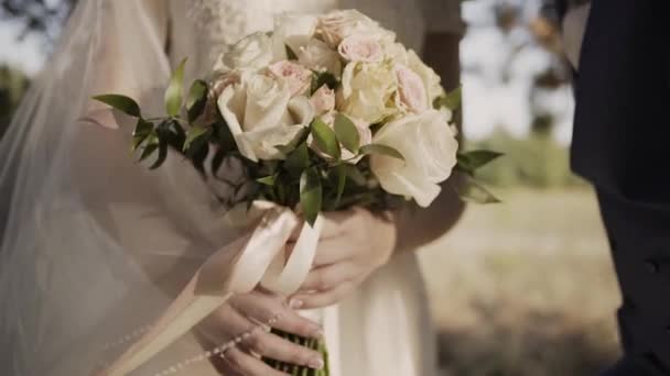Nevěsta v krajkové šaty drží krásné bílé svatební kytice. — Stock video