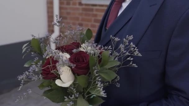 В день свадьбы свадебный букет в руках жениха . — стоковое видео