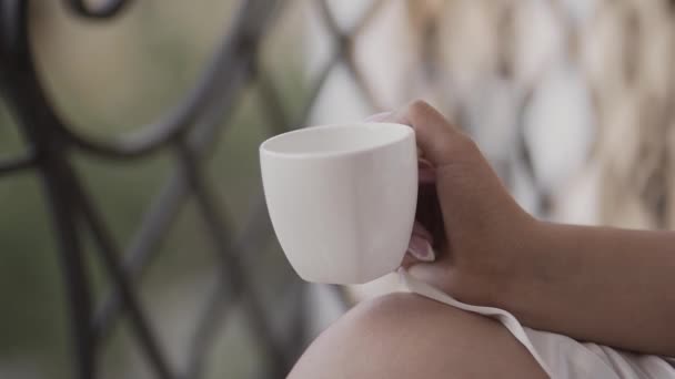 Mooie vrouw, drinken koffie op het balkon van een oud huis. — Stockvideo