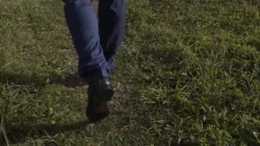 Genç bir adam bir orman yolu yürür.