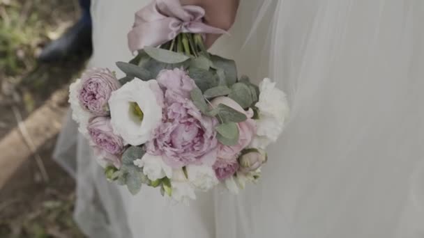 Bruden i spetsklänning holding vackra vit brudbukett blommor. — Stockvideo