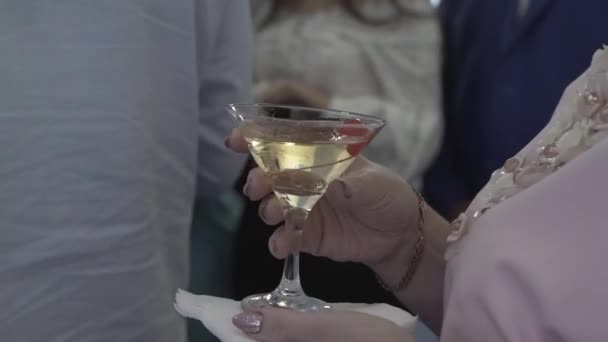 Όμορφη γυναίκα κρατά ένα οινοπνευματώδες ποτό στο χέρι. — Αρχείο Βίντεο