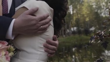 Evlen benimle bugün ve her gün. Yeni evli çift tutuşup, ağır çekimde atış.