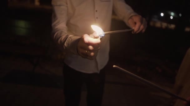 Man lights sparklers at night. — Stock Video