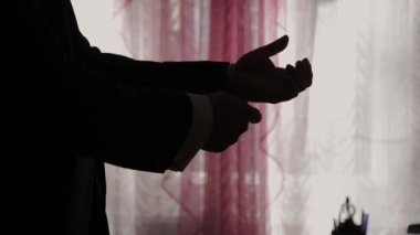 Mavi takım elbiseli başarılı adam kollarını yakın çekim düzeltiyor.