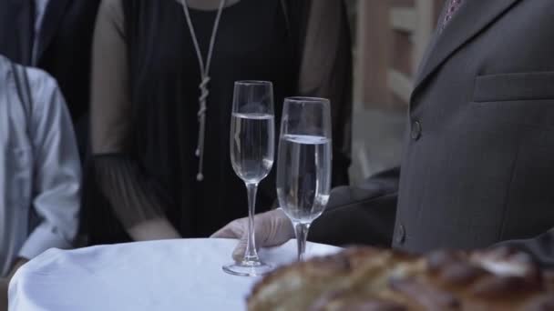 Oudere man met champagneglazen op een dienblad. — Stockvideo