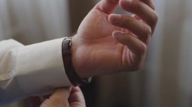 Başarılı bir adam Close-up bir kol saati koyuyor. Mens el bir saat ile saat bir saat el koyarak el mans