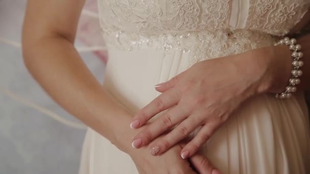 Крайне близко от рук невесты. Невеста в свадебном платье крупным планом рук. Крупным планом руки невесты на белом платье — стоковое видео