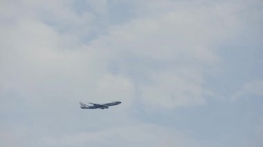 Bulutlu gökyüzüne uçan uçak. Yükselen uçak siluet bir mavi gökyüzü arka plan ile. Modern ulaşım ve Havacılık. Havaalanından kalktıktan jet yolcu uçağı. Çıkış yapan uçuş