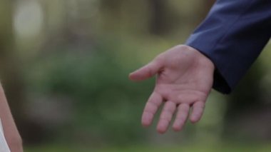 Evlen benimle bugün ve her gün. Yeni evli çift tutuşup, ağır çekimde atış.