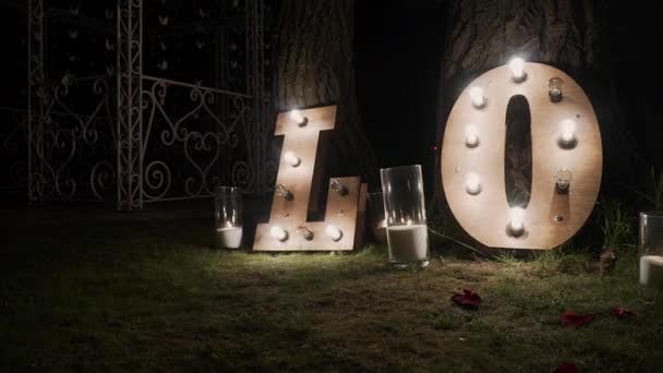 Holzbuchstaben mit Glühbirnen. Wort - Liebe. beleuchtete Wortliebe auf der Bühne. Wortliebe bestehend aus Lichtern auf Hochglanzboden — Stockvideo