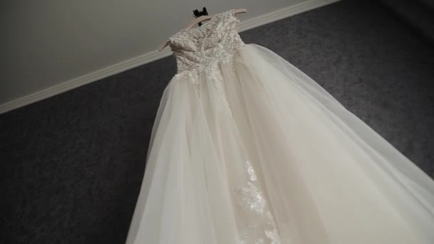 Hermoso vestido de novia colgando en una araña grande . — Vídeos de Stock