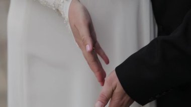 Yeni evli çift elele. Düğün çiçekleri. Yakın çekim.