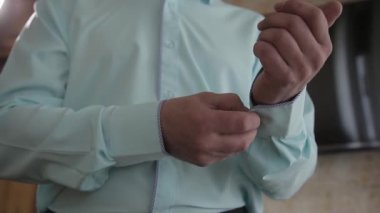 Mavi takım elbiseli başarılı adam kollarını yakın çekim düzeltiyor.