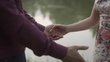 İki aşık katılmadan el ile kapatın. Ayrıntı siluet erkek ve kadın gün batımı göl arka plan üzerinde ellerimi. Çift güven, sevgi ve mutluluk kavramı.