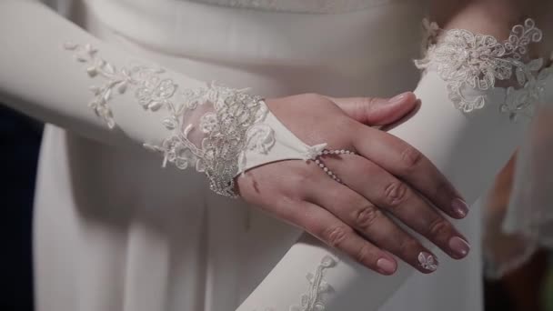 Extrême près des mains de la mariée. Mariée en robe de mariée gros plan des mains. Gros plan mains de la mariée sur robe blanche — Video