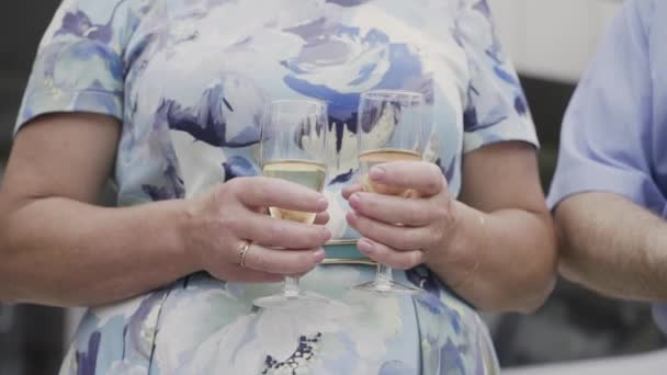 Mature woman holding champagne glasses. — Stock Video