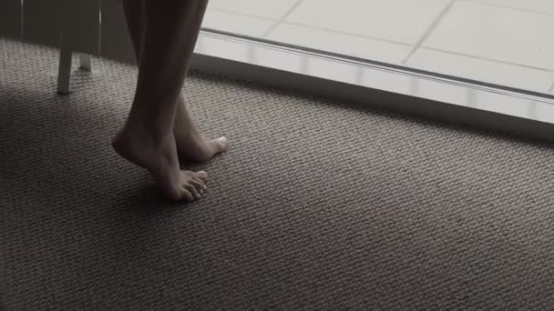 Beautiful girl standing on tiptoes by the window. — Stock Video
