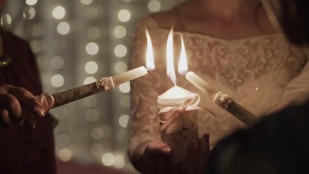 Свічка запалила ще одну свічку в руках . — стокове відео
