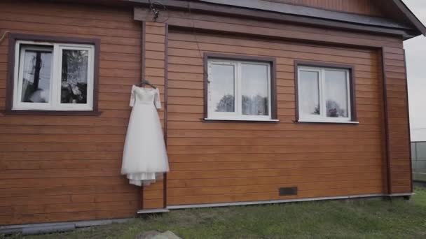 Piękna suknia wisi na drewniany dom. — Wideo stockowe