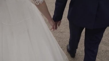 Evlen benimle bugün ve her gün. Yeni evli çift tutuşup, ağır çekimde atış.
