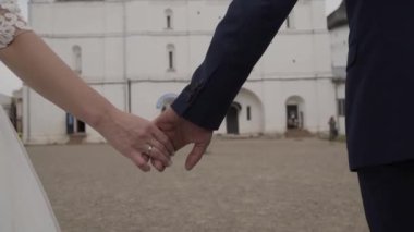 Evlen benimle bugün ve her gün. Yeni evli çift tutuşup, ağır çekimde atış.