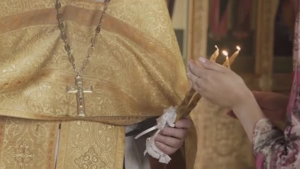 El Sacramento del Bautismo en la Iglesia Ortodoxa. Primer plano de un sacerdote encendiendo velas en una fuente . — Vídeo de stock