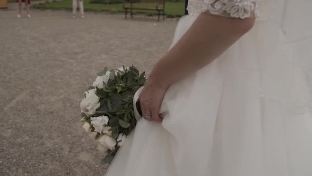 Νύφη στο φόρεμα δαντέλα κρατώντας όμορφο άσπρο γαμήλιο μπουκέτο με λουλούδια. — Αρχείο Βίντεο